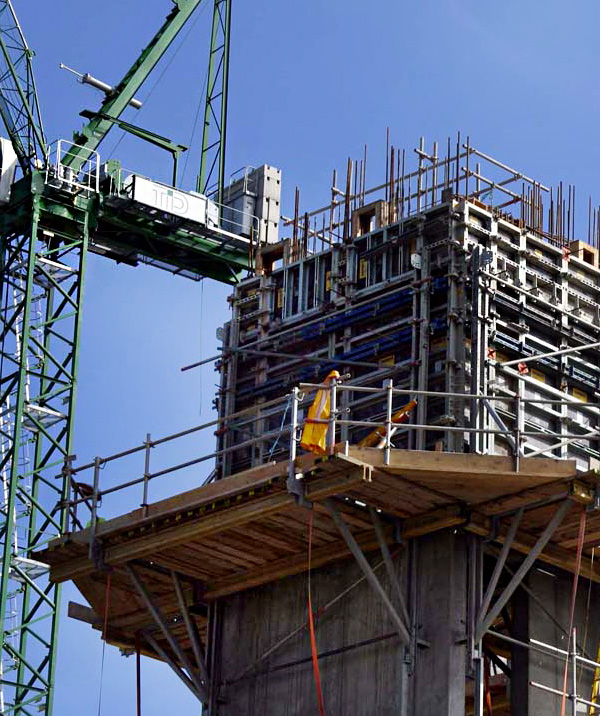 building surrounded by crane and scaffolding